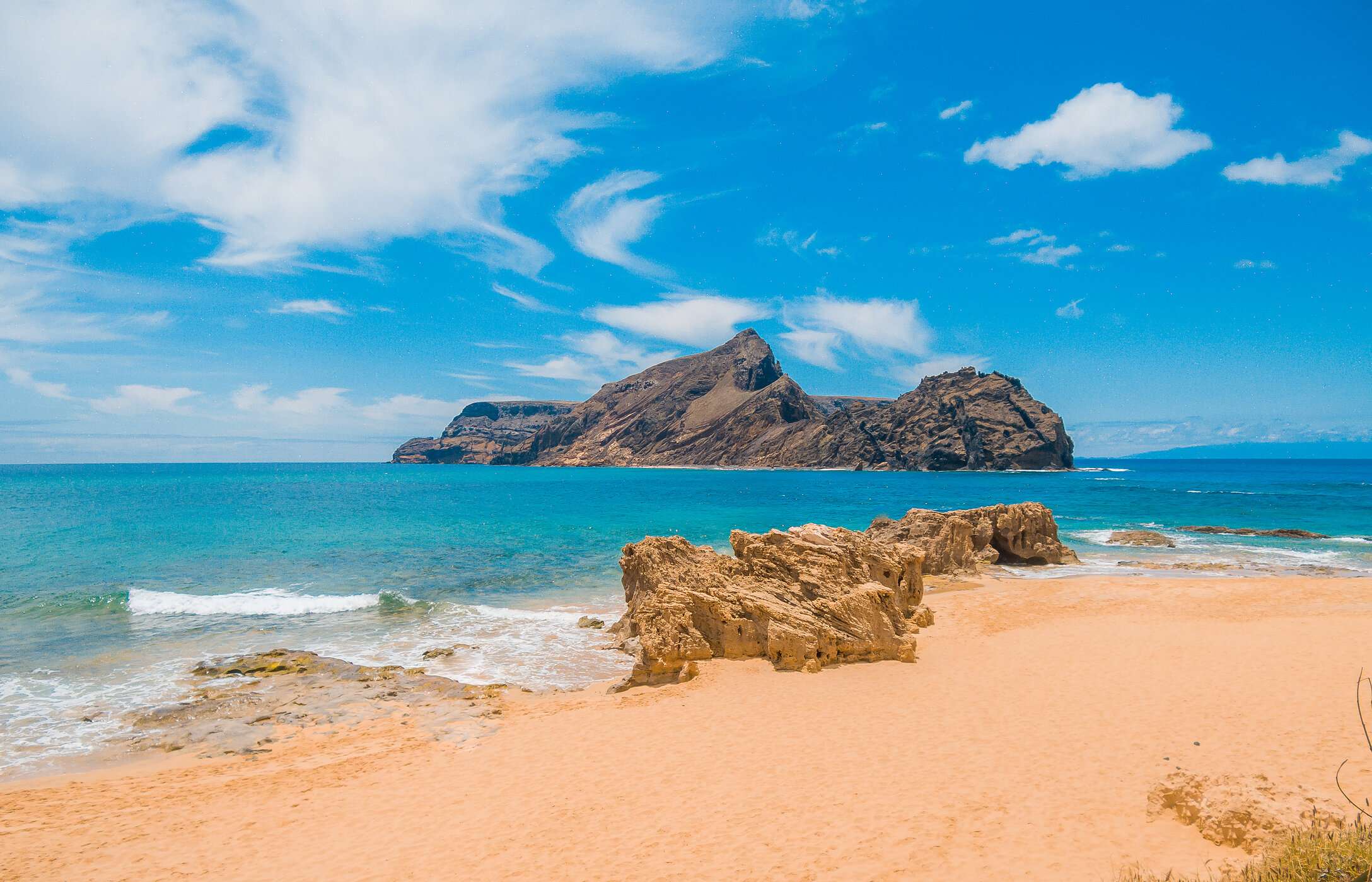 Strand van Porto Santo, met goudkleurig zand en kristalhelder water met een tweede eiland op de achtergrond