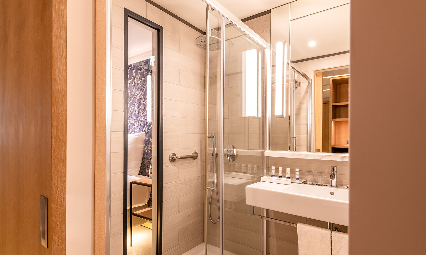 De Deluxe River View kamer van Pestana Douro Riverside heeft een badkamer met wastafel, spiegel en douche