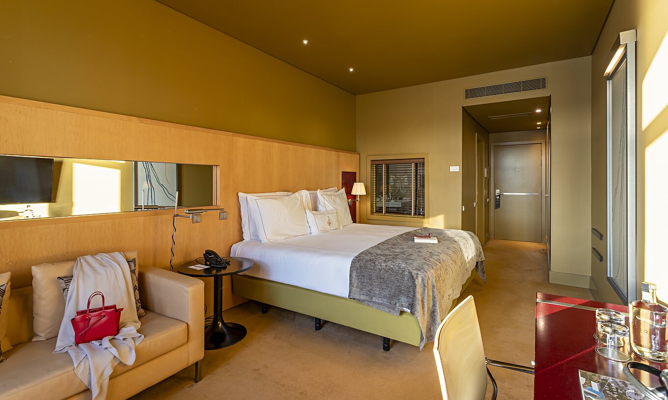 De Executive Superior heeft een tweepersoonsbed, een bank en een rood bureau