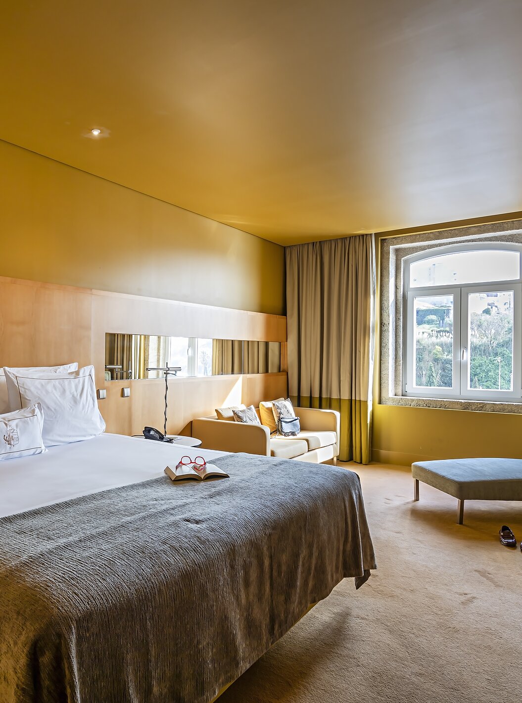 De Superior kamer van Pestana Palácio do Freixo heeft een tweepersoonsbed met een grijze sprei en een raam met uitzicht