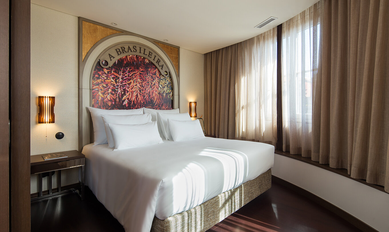 De Master Suite van Pestana Porto - A Brasileira heeft een queen size tweepersoonsbed met uitzicht over Rua Sá da Bandeira