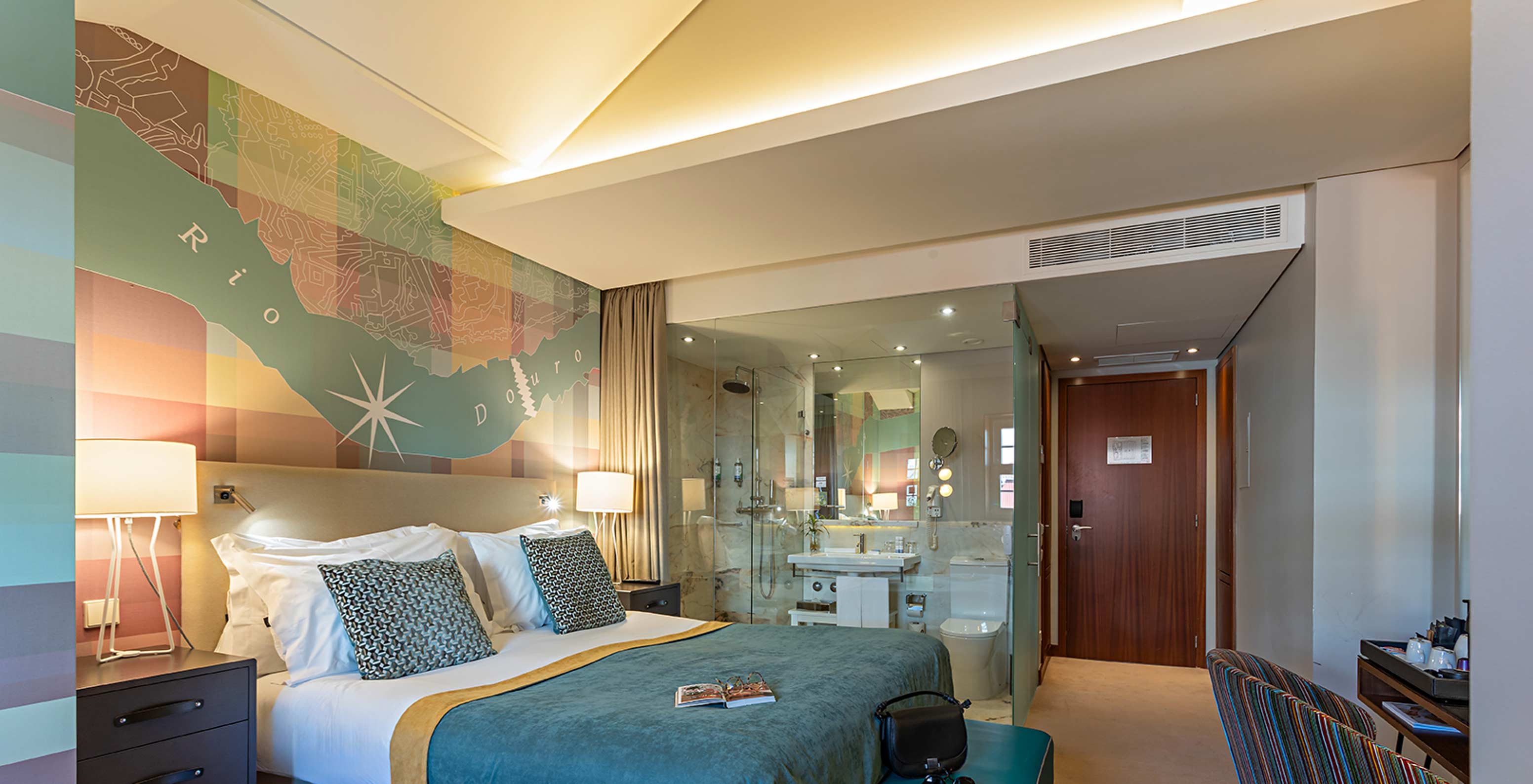 De Classic van het Pestana Vintage Porto heeft een tweepersoonsbed met een blauwe sprei en een bureau met een stoel