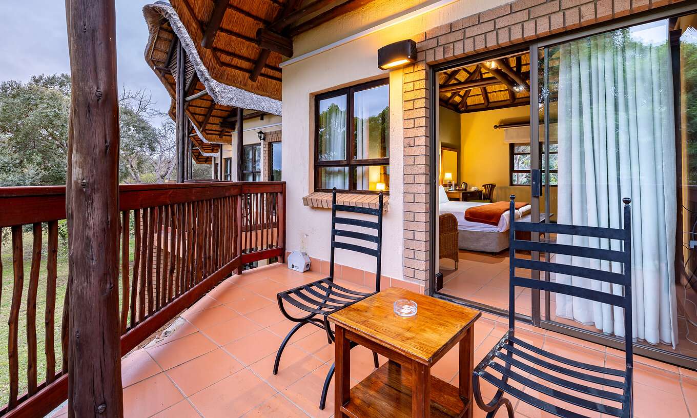 De Standaard Kamer Van Pestana Kruger Lodge Heeft Een Balkon Met Houten Details Twee Stoelen En Een Tafel