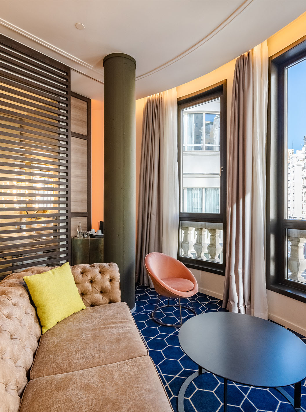 De Amazing CR7 van Pestana CR7 Gran Vía Madrid heeft een bank, twee tafels en grote ramen met uitzicht op de Gran Vía