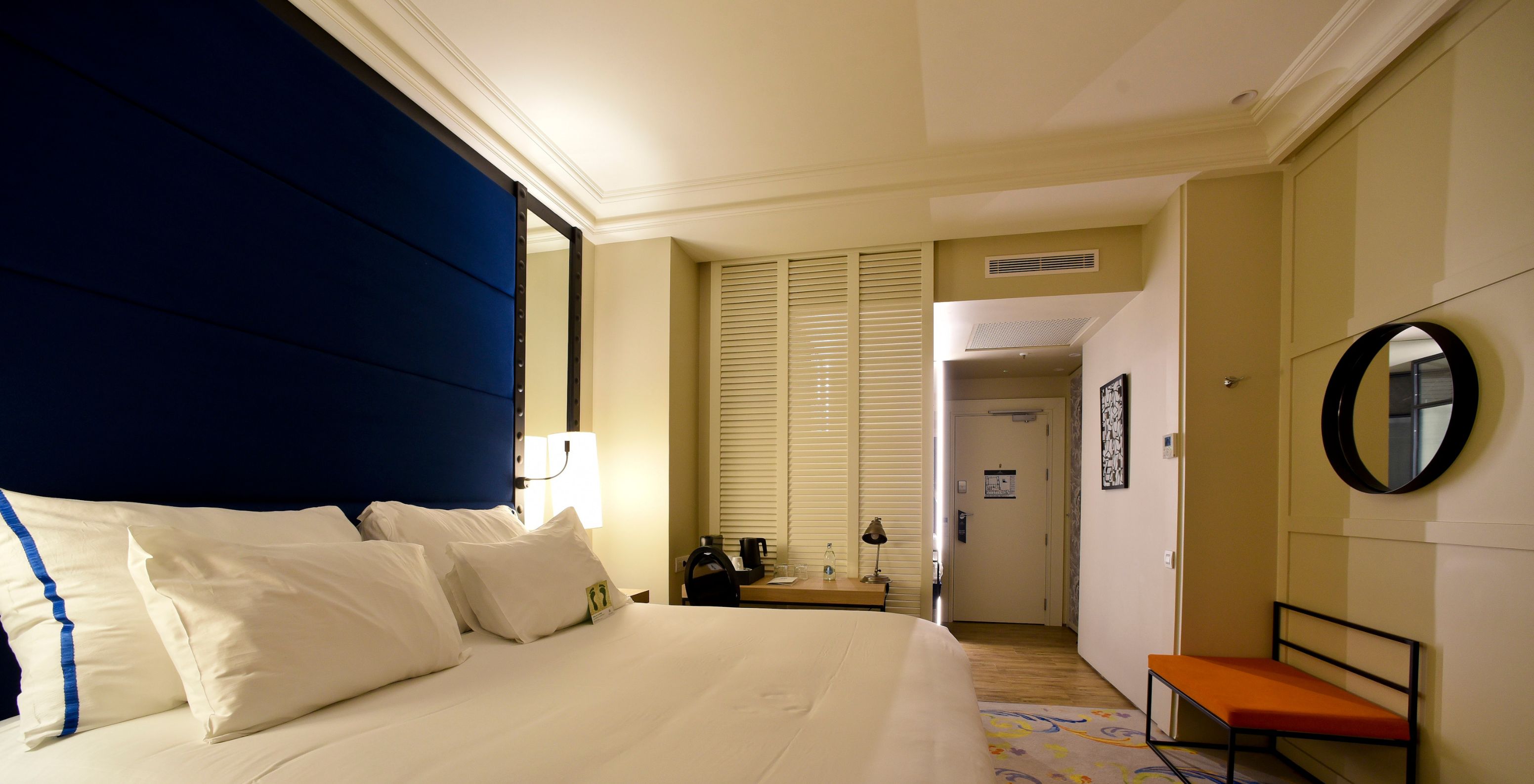 De Superior Plus Kamer in Pestana Collection Plaza Mayor heeft een tweepersoonsbed met een lamp en een tapijt.