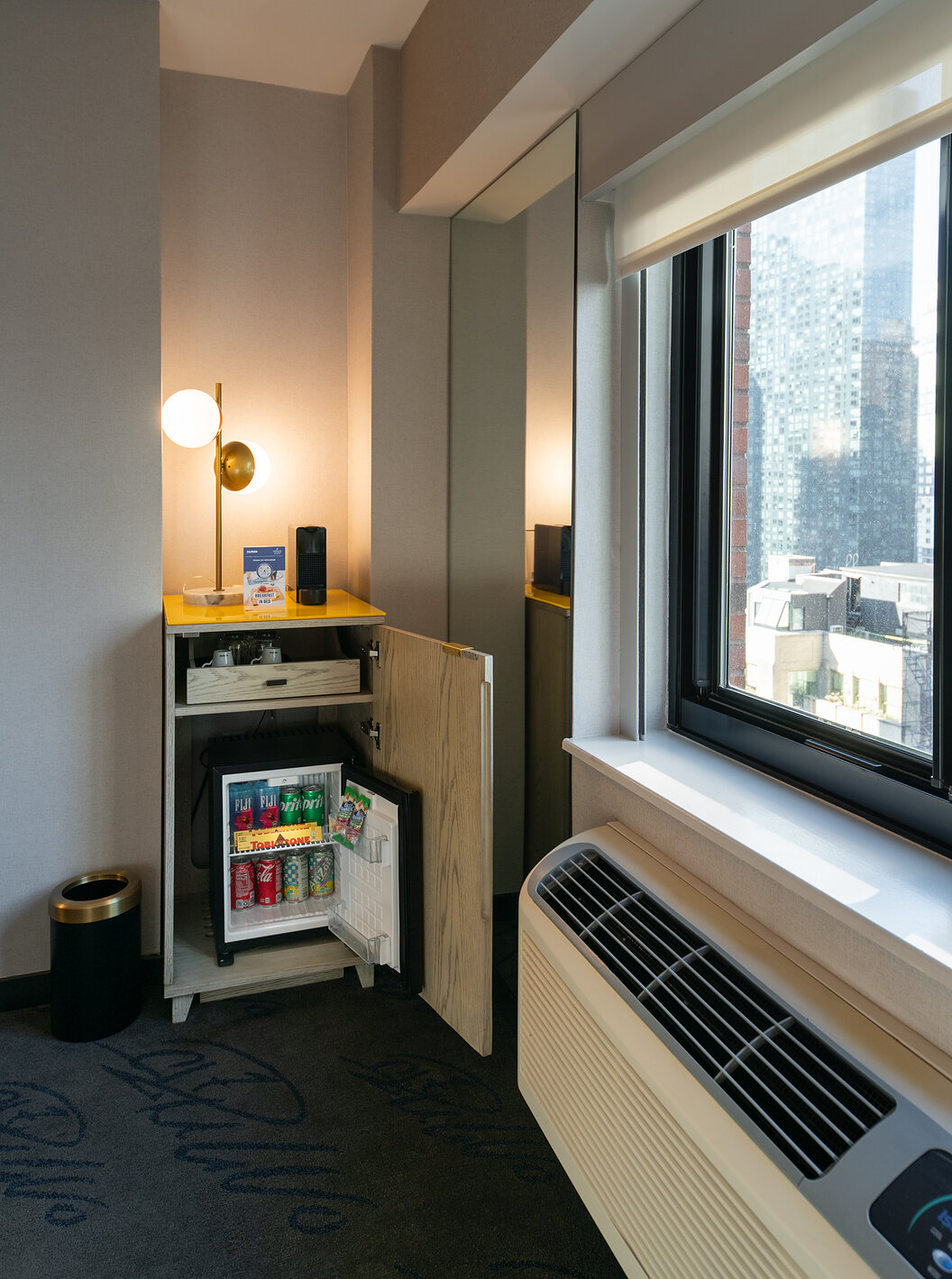 De Deluxe King Room van Pestana CR7 Times Square heeft een kledingkast met een minibar bij het raam