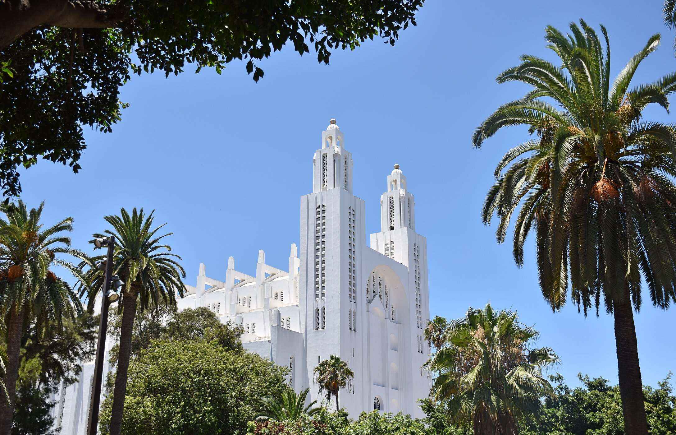 Vista da Catedral com paredes brancas de Casablanca rodeada por diferentes árvores no centro da cidade
