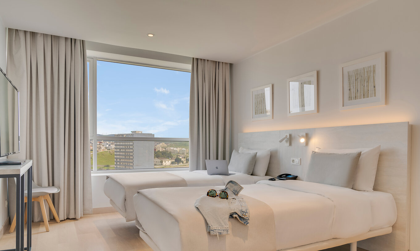 A Suite Familiar Premium do Pestana Tanger City Center conta com duas camas separadas com cabeceira em pedra e uma janela