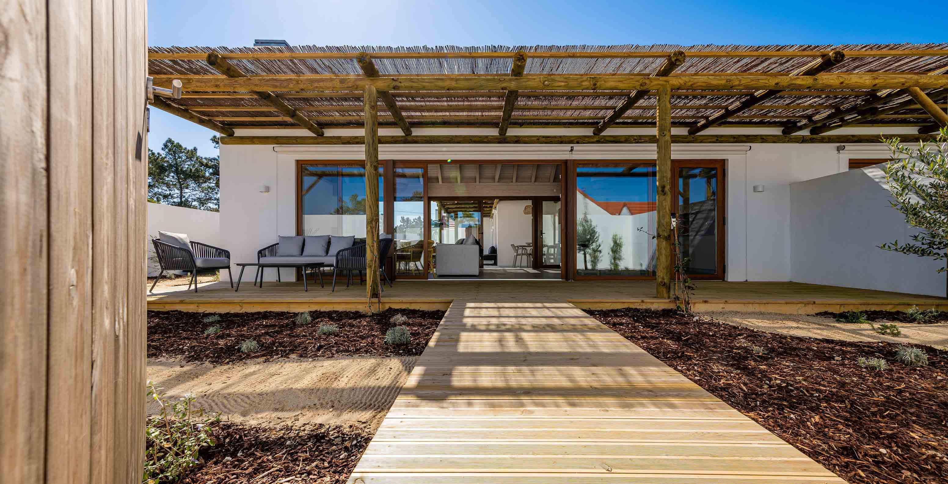 A Premium Villa do Pestana Comporta Village Residences tem uma entrada com deck de madeira, uma pérgola e um jardim