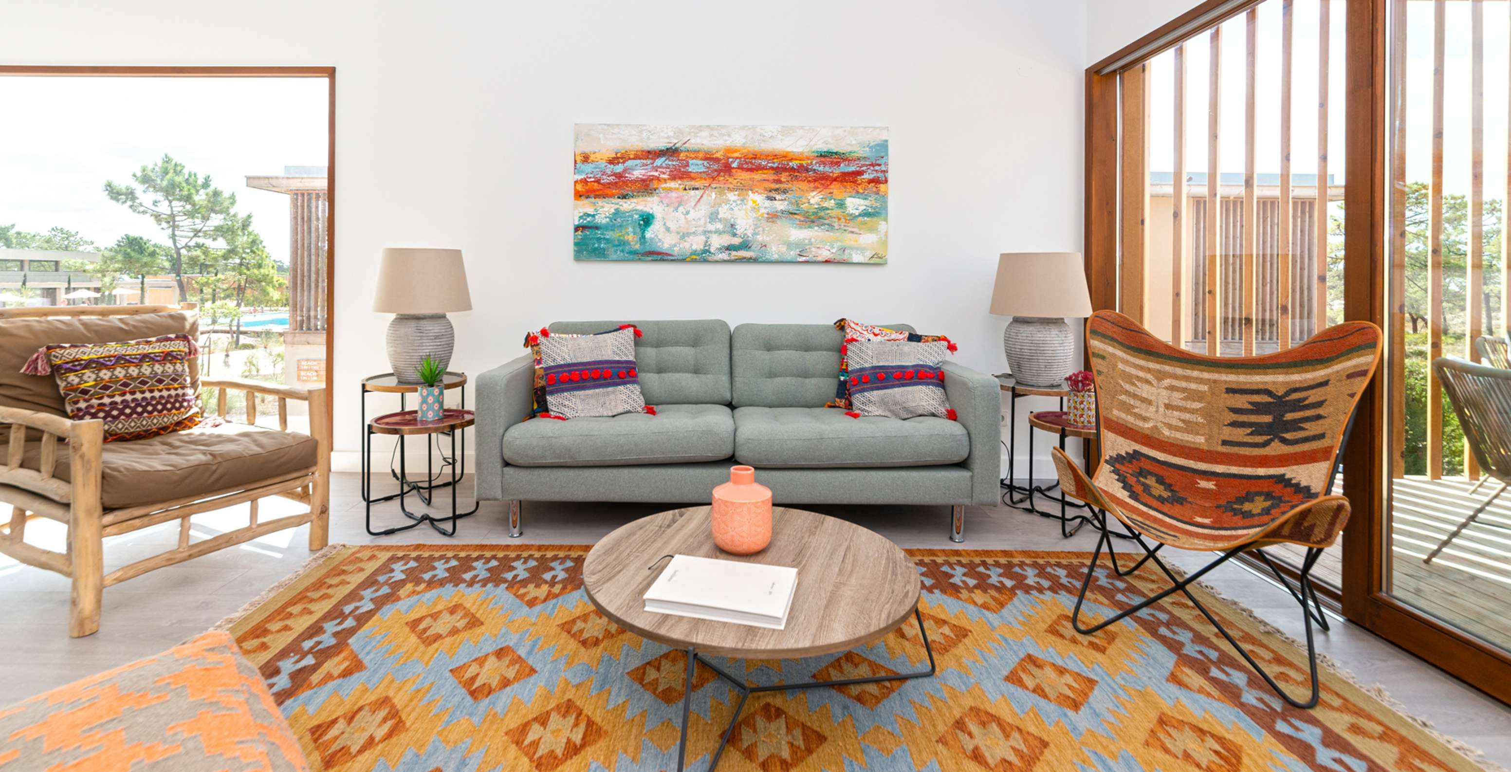 O Apartamento Eco Village 1º Andar do Pestana Tróia Eco Resort tem um sofá, várias cadeiras, um tapete e mesa de apoio