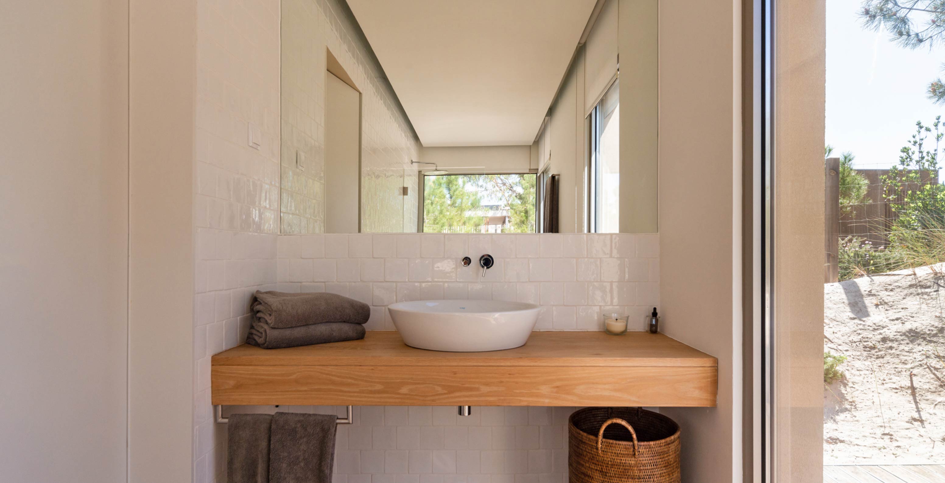 A Villa exclusiva com piscina do Pestana Tróia Eco Resort tem uma casa de banho com lavatório, bancada de madeira e espelho