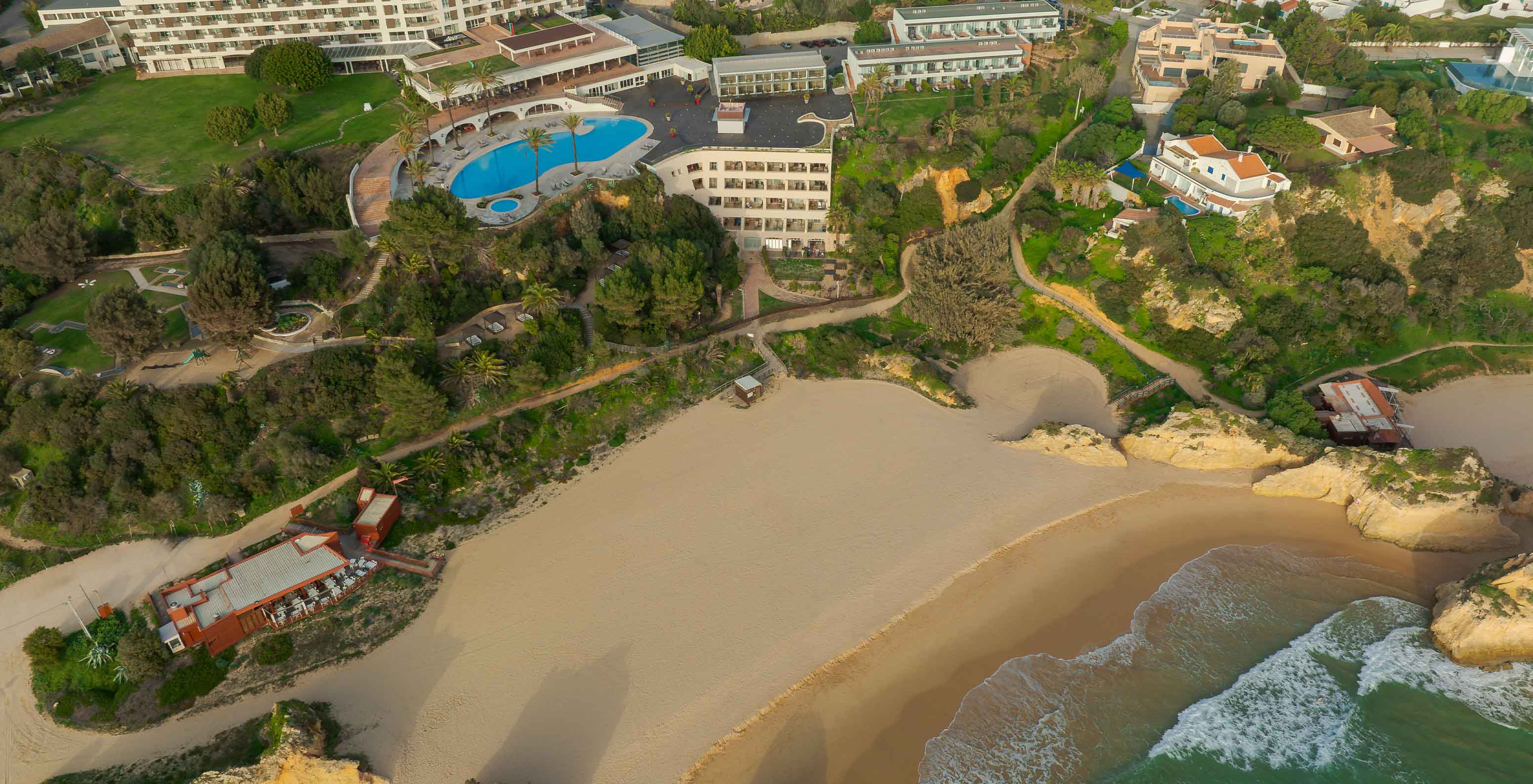 Vista aérea do hotel Pestana Alvor Praia com a Praia dos Três Irmãos em frente, com as rochas, areia e oceano