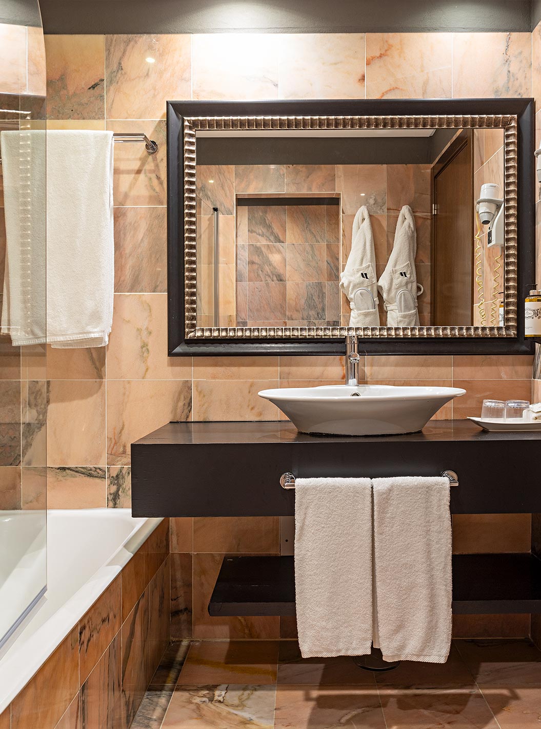 A Cliff Suite T1 do Pestana Alvor Praia tem uma casa de banho com uma banheira, dois roupões e um secador de cabelo