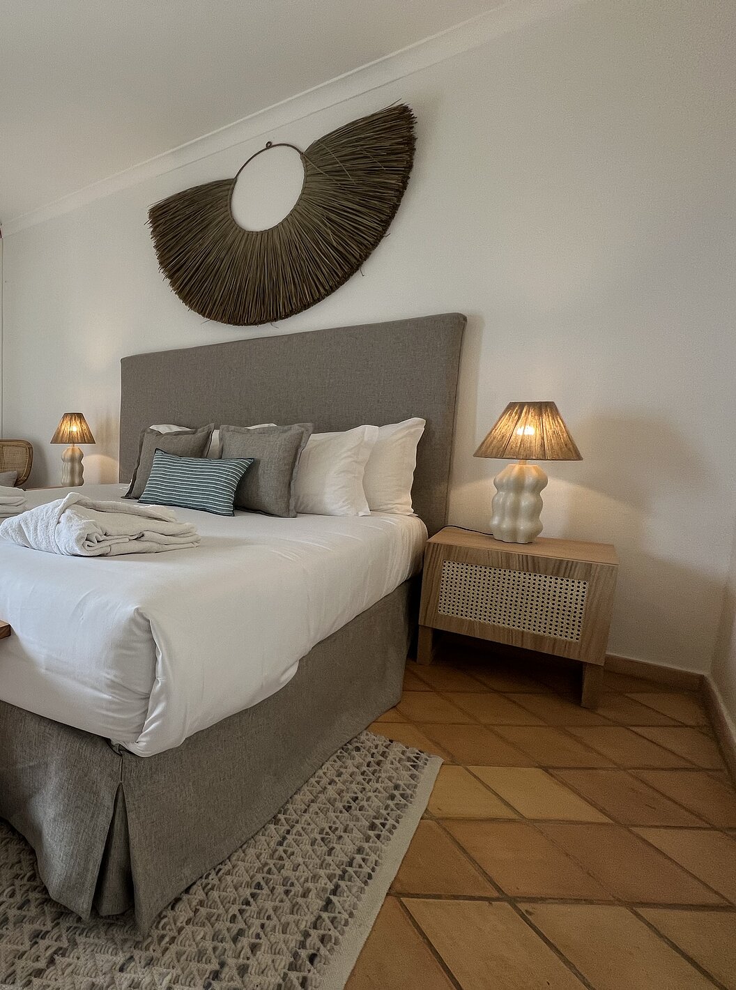 O Apartamento T2 Premium do Pestana Palm Gardens tem uma cama com dois roupões, almofadas e uma janela com varanda