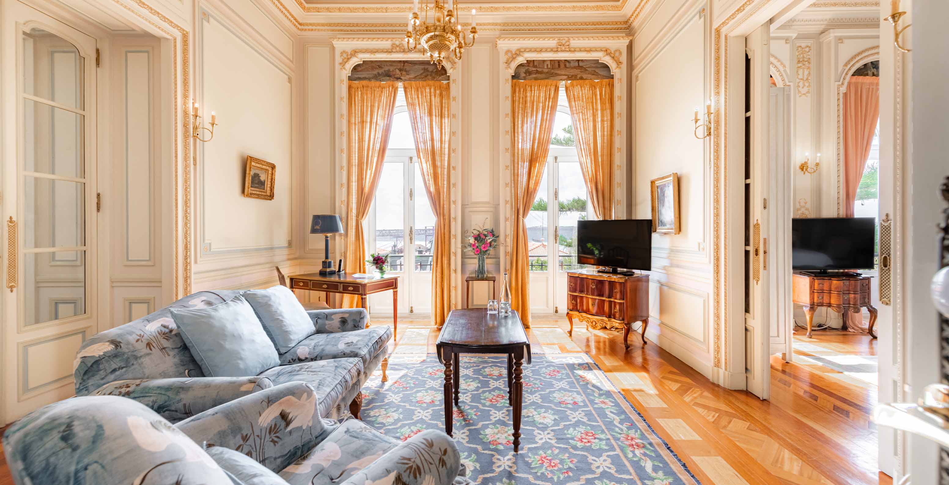 A Suite D. Manuel do Pestana Palace Lisboa tem uma sala de estar luxuosa com sofá, televisão, janela e tapete
