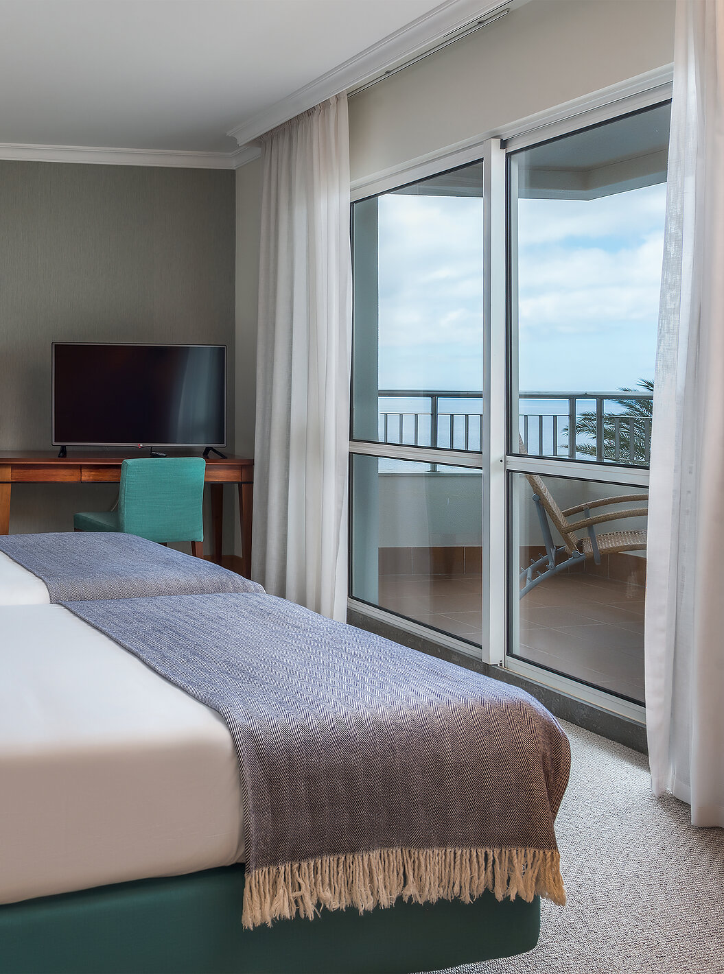 A Standard Suite Vista Mar do Pestana Grand tem duas camas individuais, televisão e secretária 