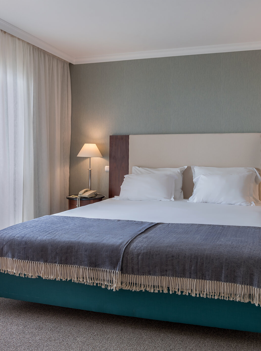 O quarto Twin Superior Vista Mar do Pestana Grand tem cama de casal com mesa de cabeceira e candeeiros