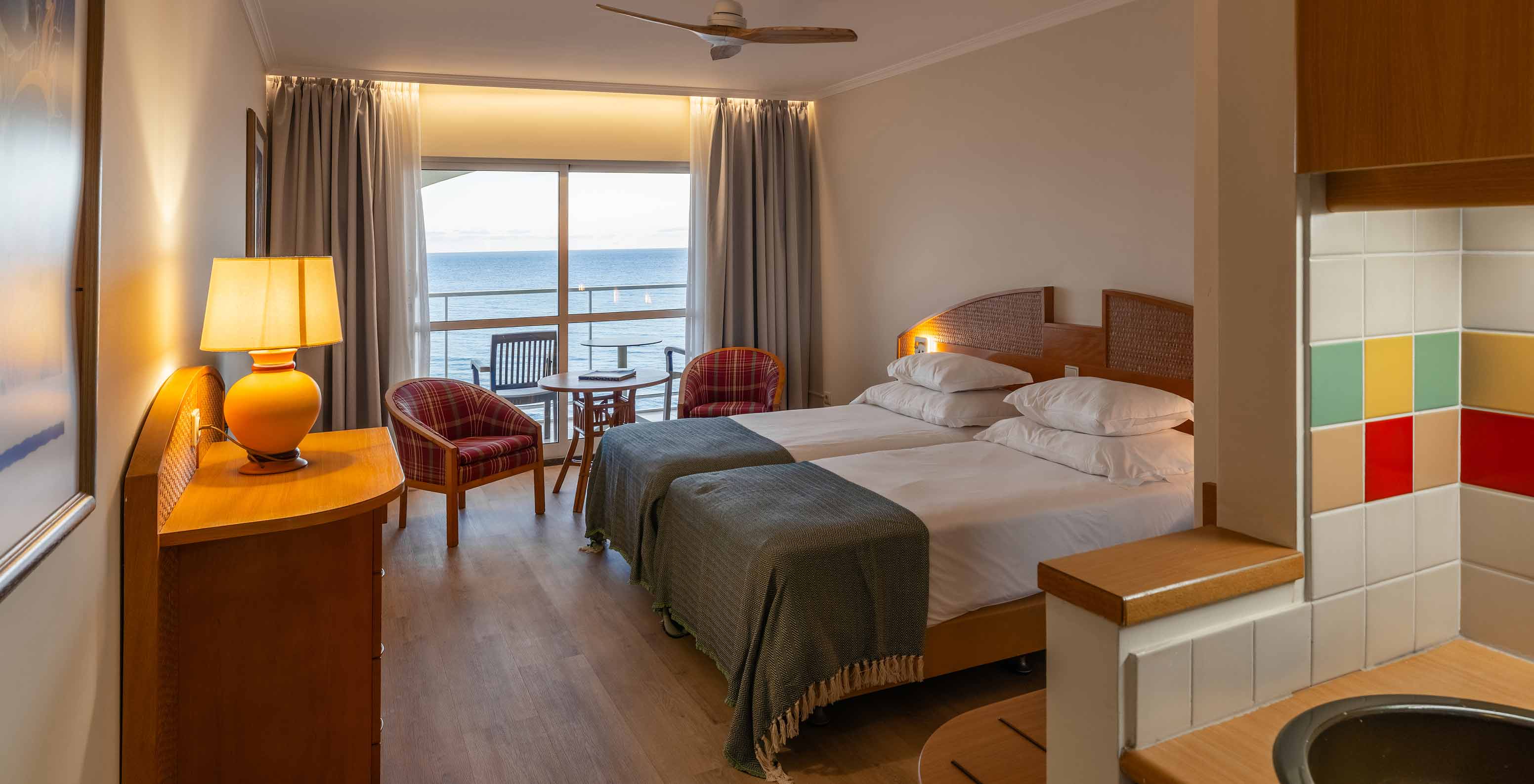 O Superior Sea View  do Pestana Ocean Bay All Inclusive tem uma cama dupla, duas poltronas e varanda com vista mar 
