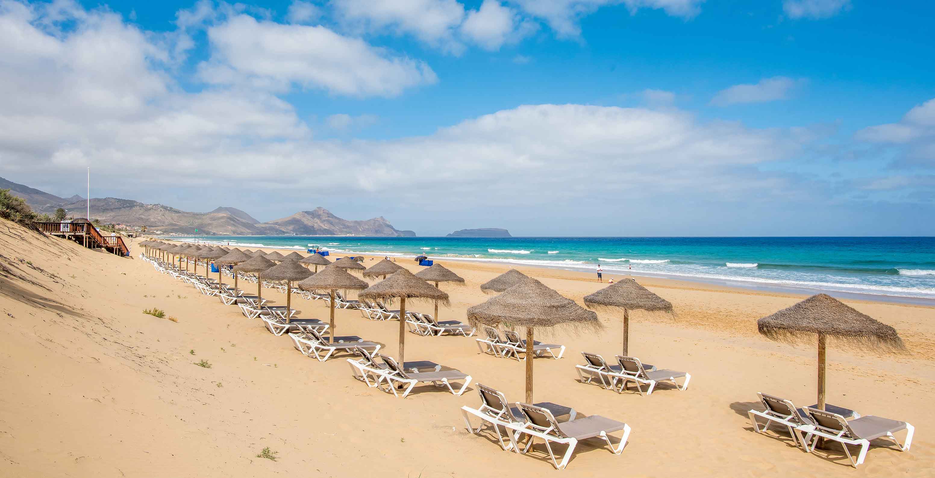 O Beach Bar,  Resort de 5 Estrelas no Porto Santo tem uma praia, com mar calmo e azul, com vários toldos