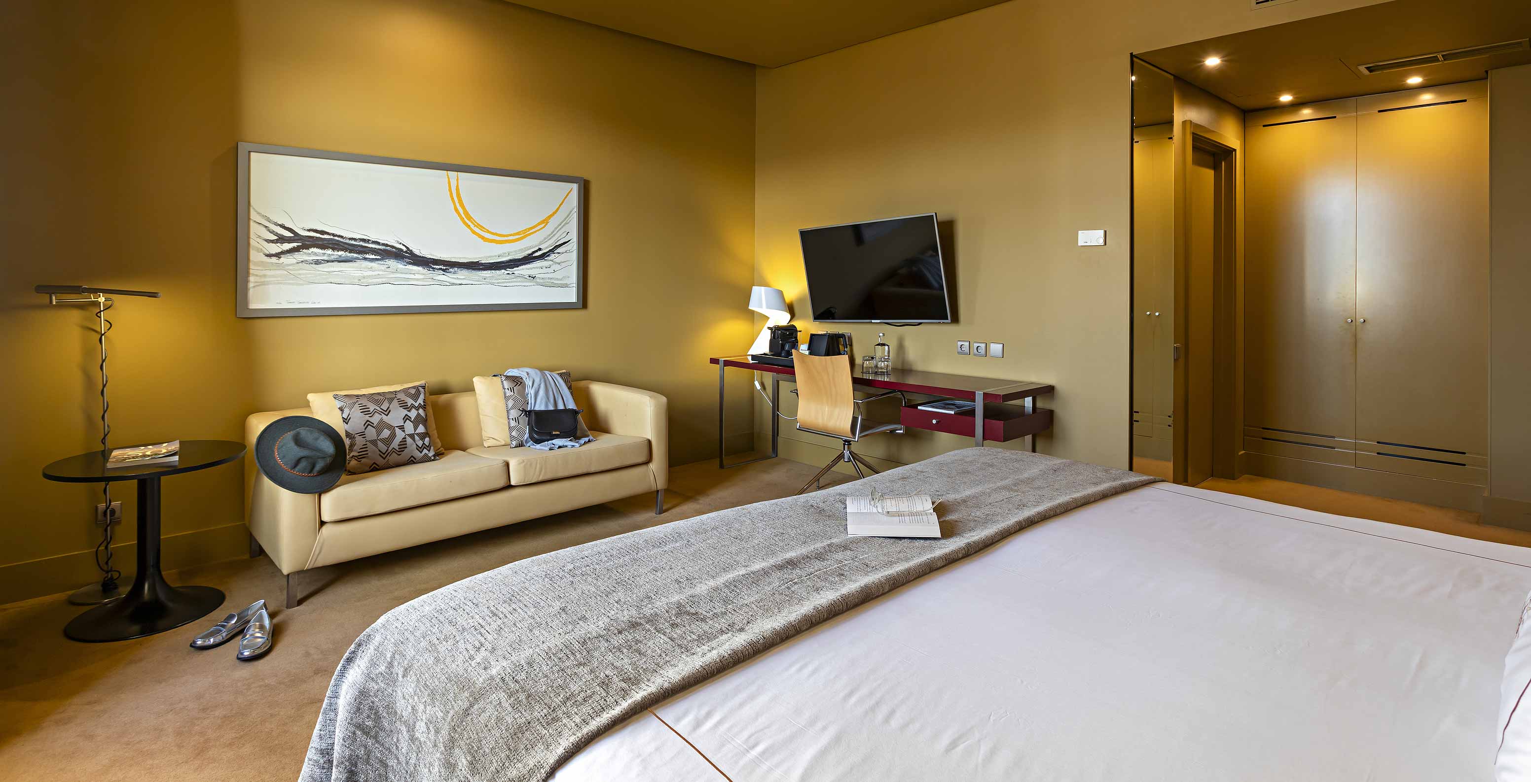 O Executive do Pestana Palácio do Freixo tem um cama de casal, um sofá, uma tv e uma secretária