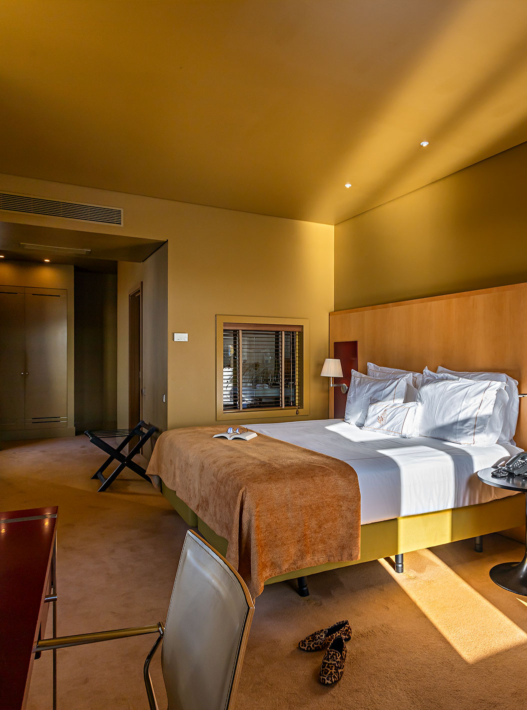 O Deluxe Grand View do Pestana Palácio do Freixo tem uma cama de casal com uma manta camel, um sofá e uma secretária