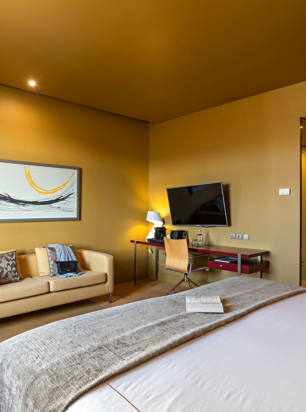 O Executive do Pestana Palácio do Freixo tem um cama de casal, um sofá, uma tv e uma secretária