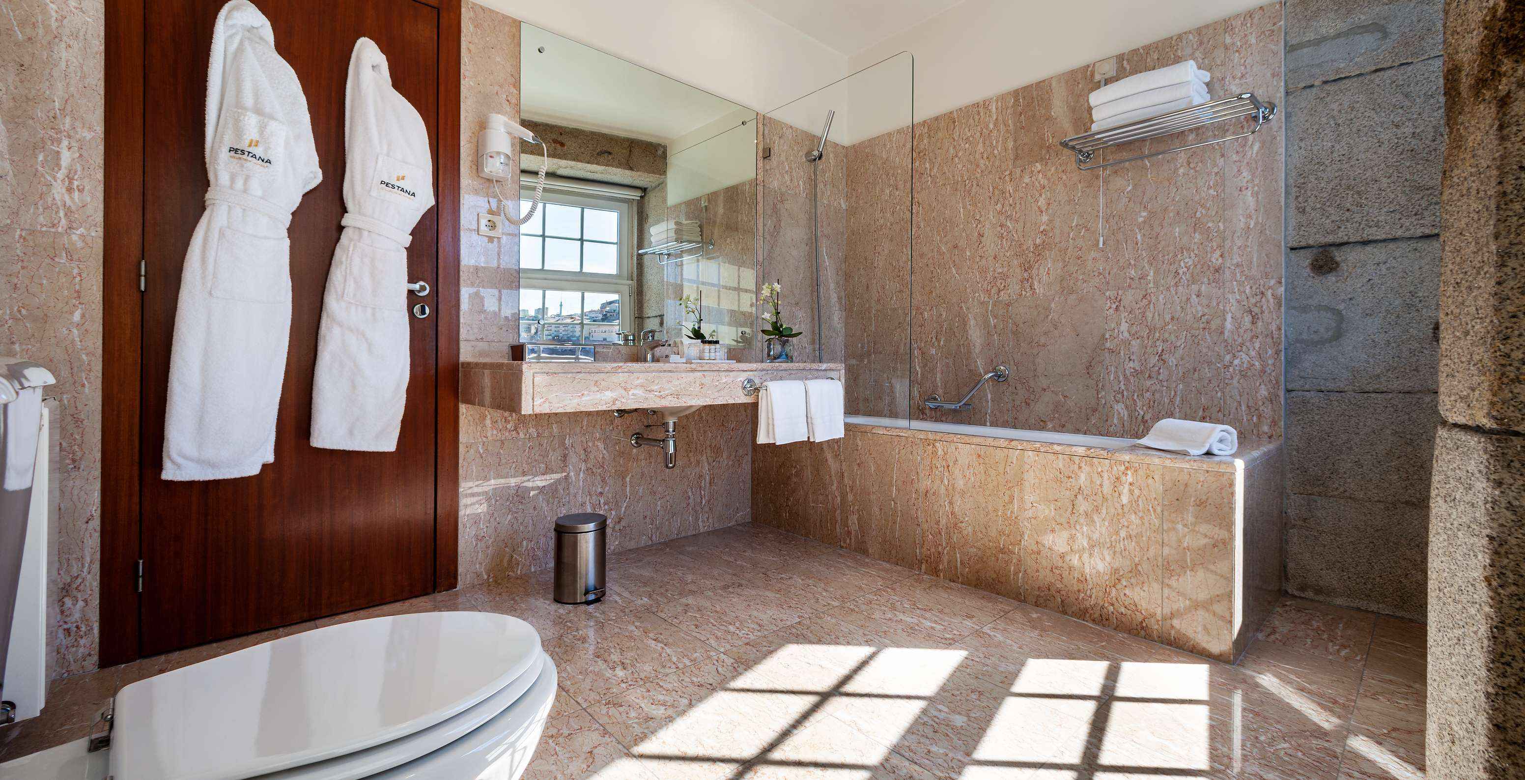 O Plaza do Pestana Vintage Porto tem uma casa de banho com banheira, dois roupões, lavatório e secador de cabelo