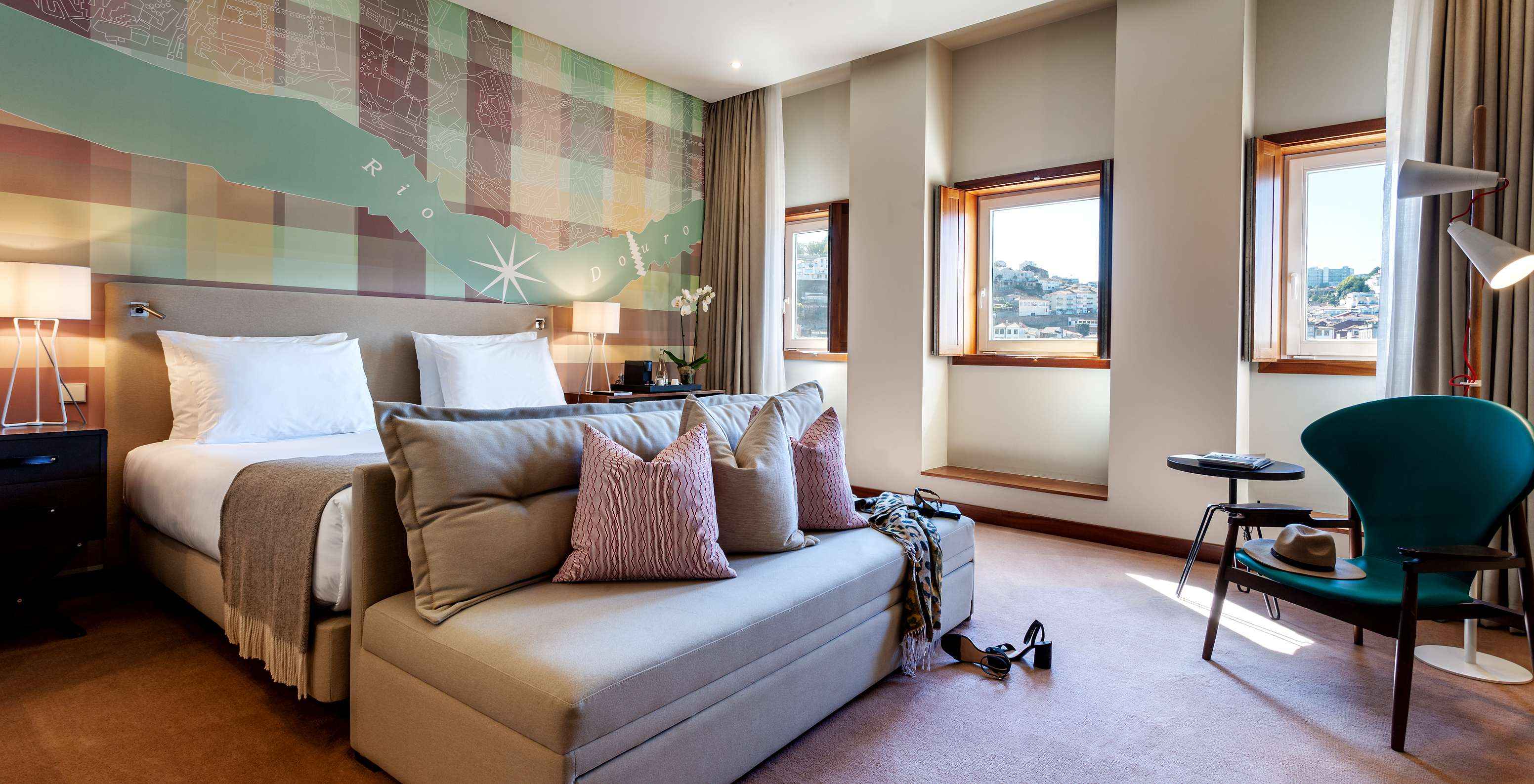 O Vintage Front View do Pestana Vintage Porto tem uma cama de casal com um sofá aos pés, três janelas e um cadeirão