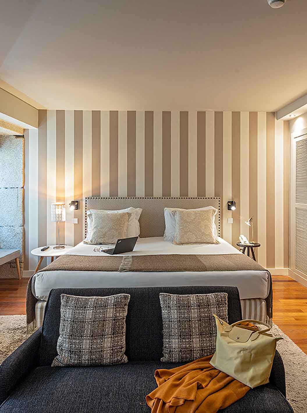 A Heritage Suite do Pestana Vintage Porto tem uma cama de casal, um sofá, uma secretária e um roupeiro branco