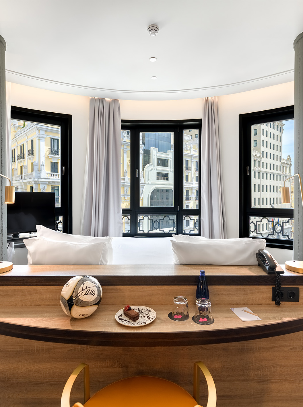 O Deluxe Grand com Vista do Pestana CR7 Gran Vía Madrid tem uma cama de casal virada para as janelas em parede arredondada
