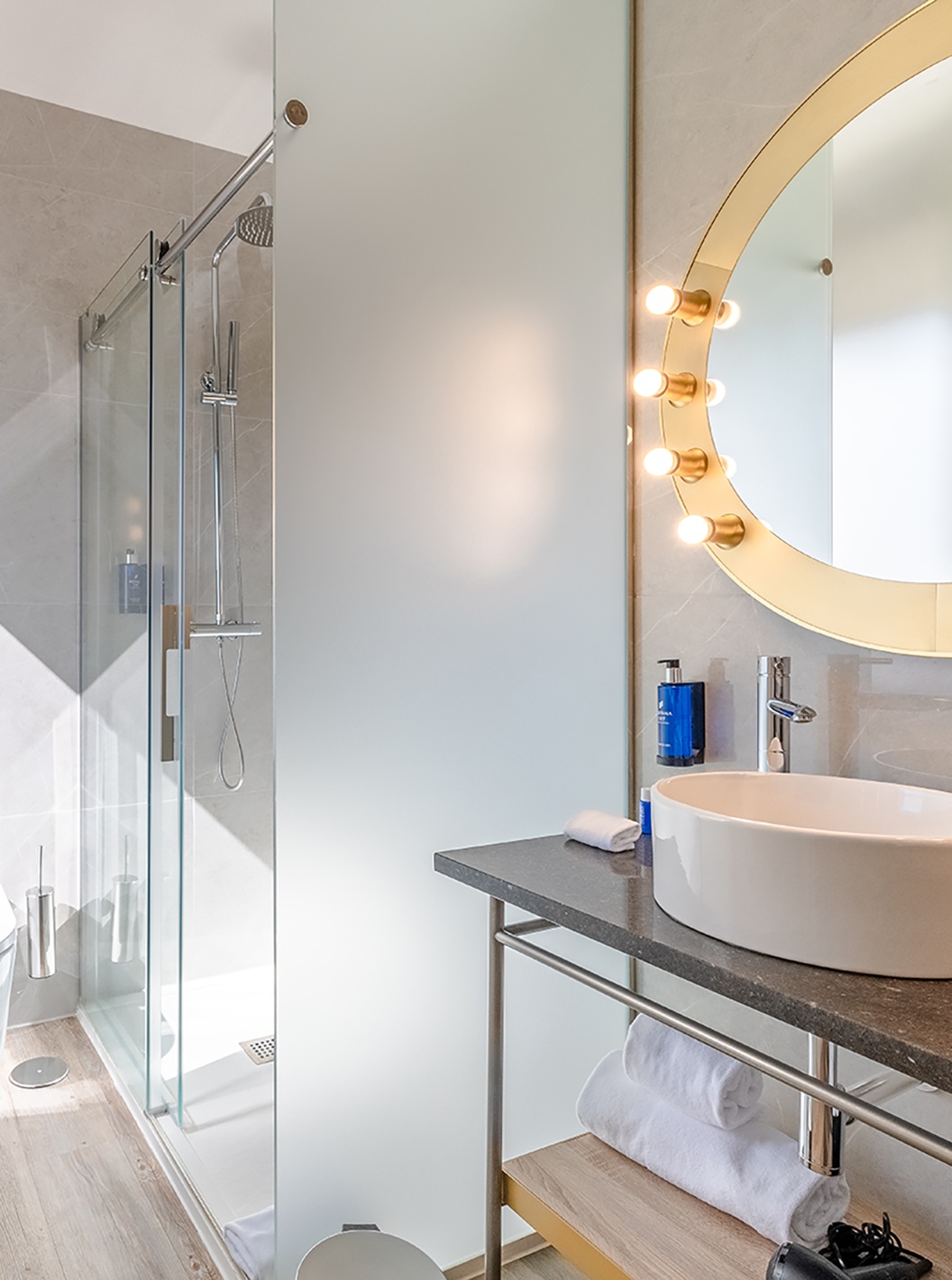 O Small Double Room do Pestana CR7 Gran Vía Madrid tem uma casa de banho com um espelho redondo com luzes