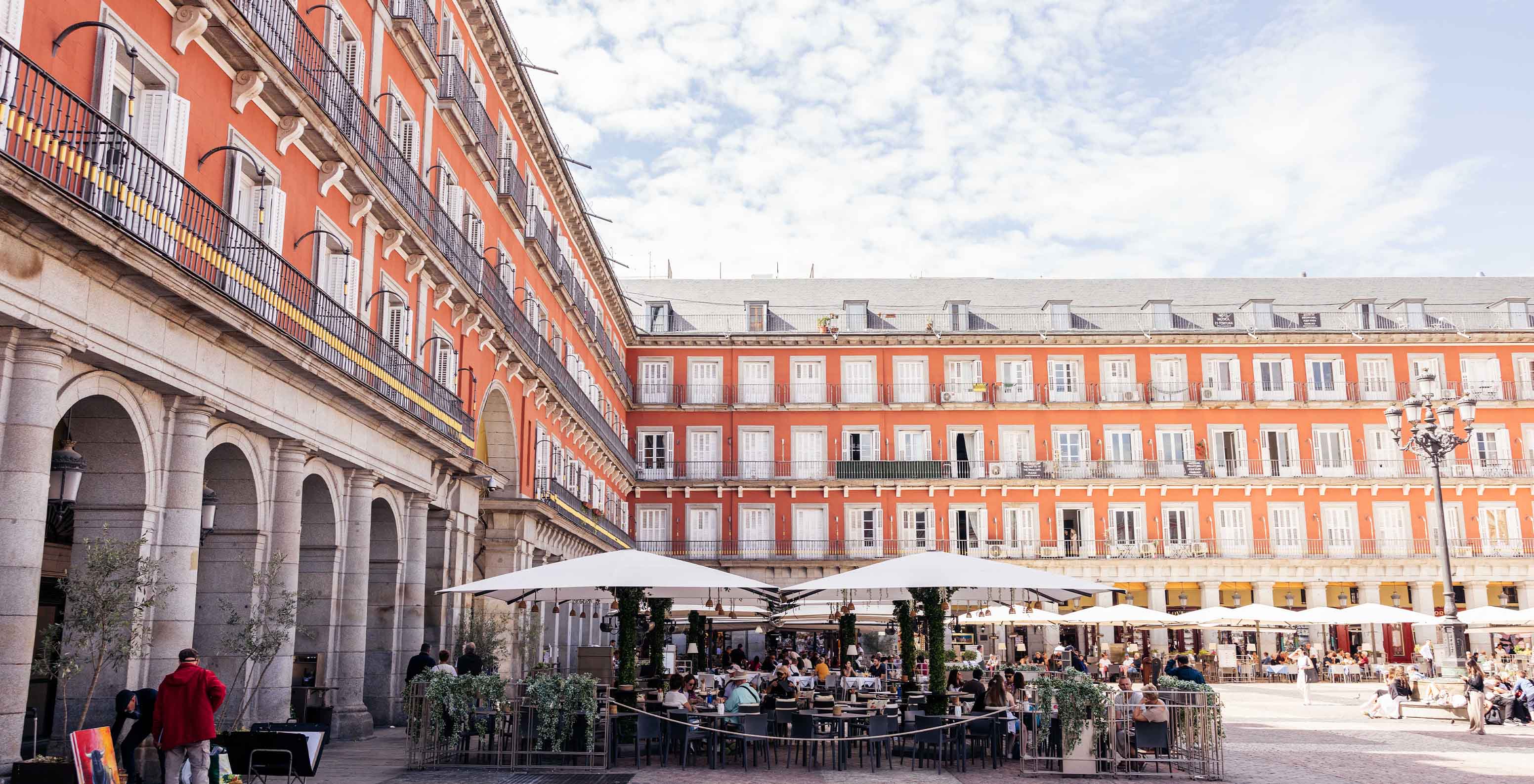 Vista da esplanada do restaurante do Pestana Collection Plaza Mayor, com chapéus de sol e mesas, no centro da Plaza Mayor