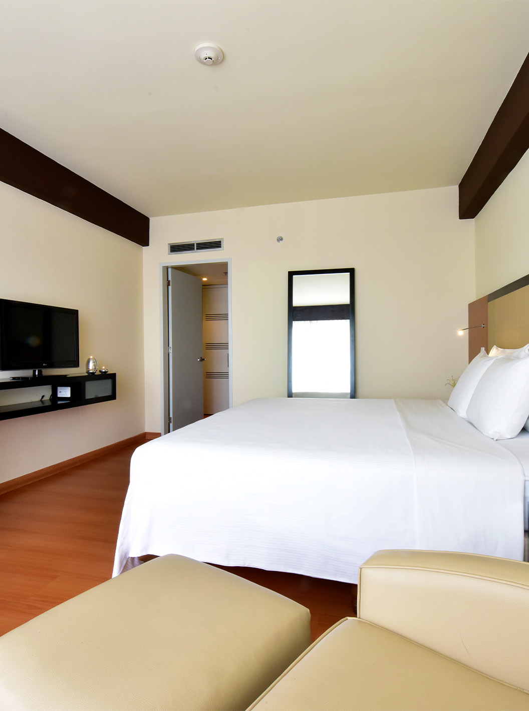 O Twin Superior do Pestana Caracas tem uma cama de casal, um espelho, uma secretária e uma poltrona