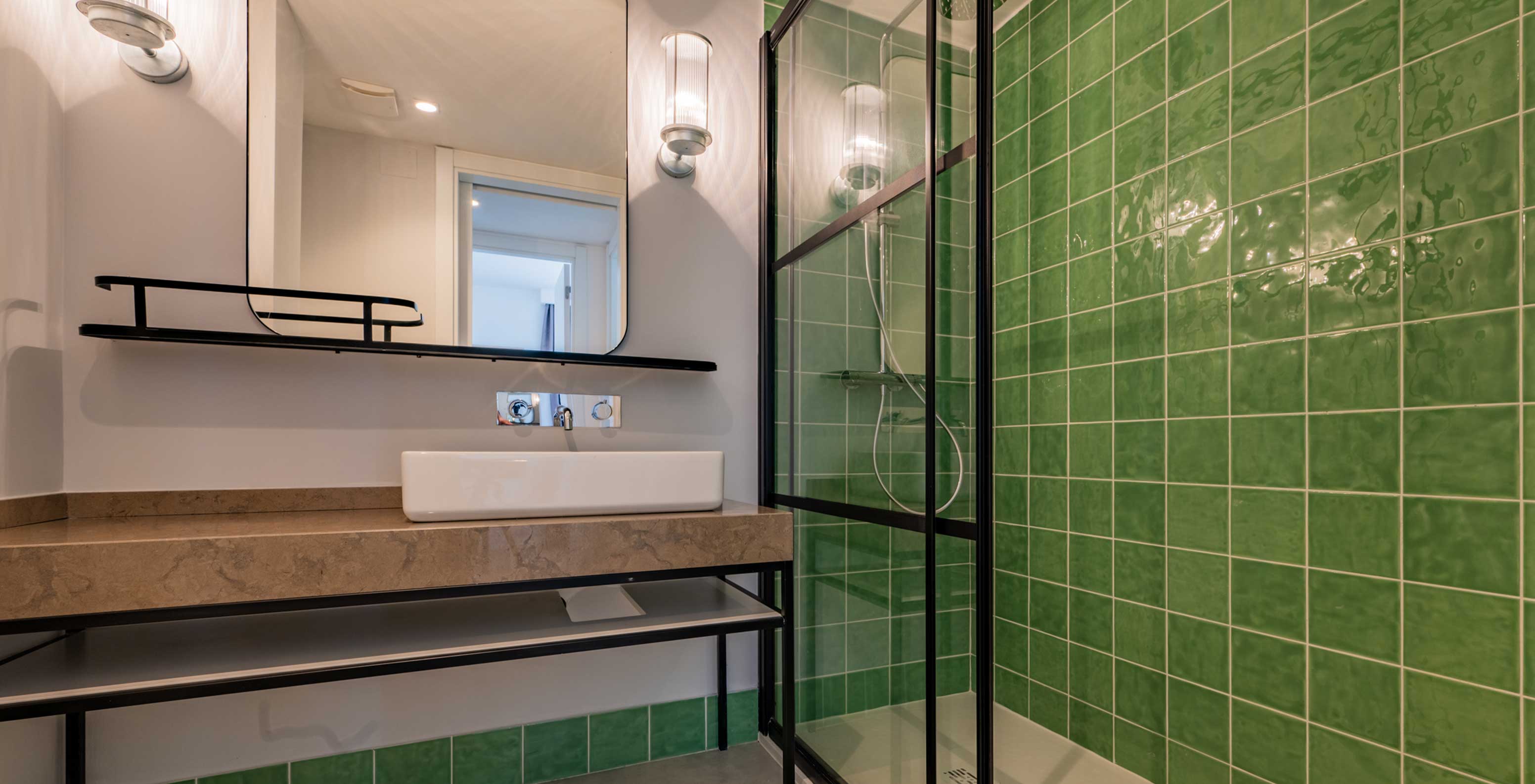 Casa de banho do Pestana Porto Covo Village com lavatório moderno e duche com azulejos verdes