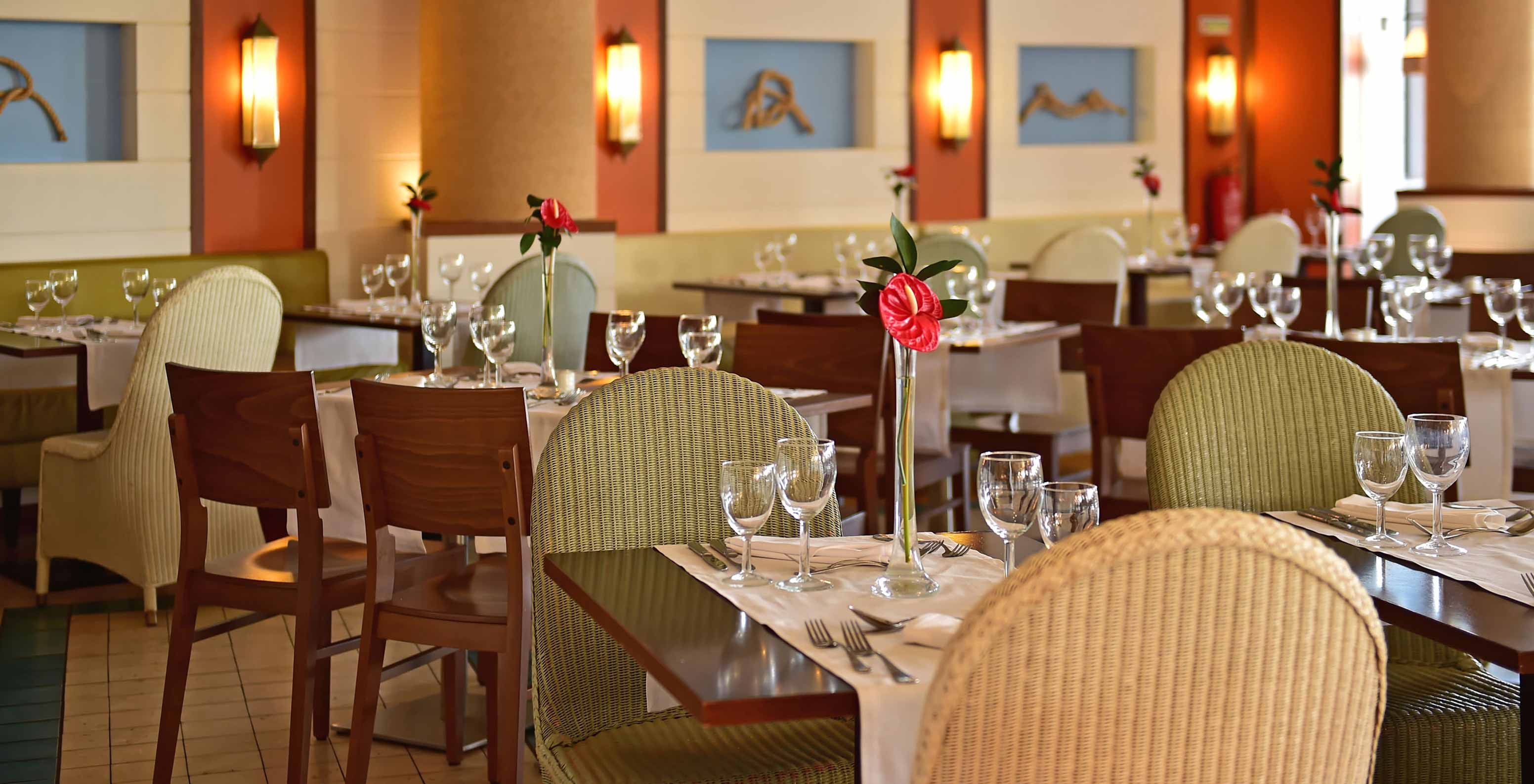 Restaurante do Pestana Porto Santo, Hotel com Tudo Incluído e Spa no Porto Santo, com mesas elegantes e copos dispostos