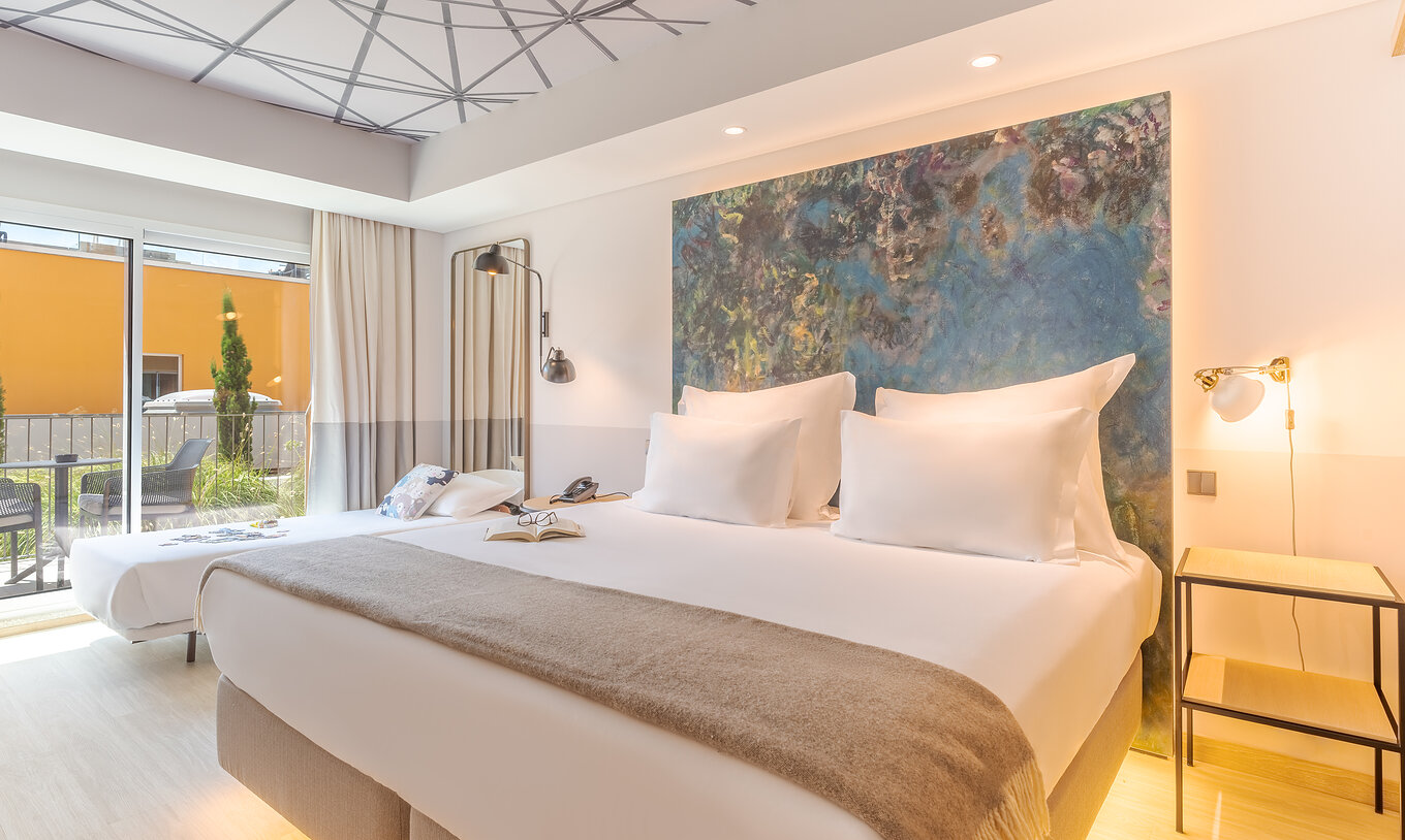 O quarto Superior Familiar do Pestana Douro Riverside conta com uma cama de casal e uma cama pequena, mesa de cabeceira e varanda