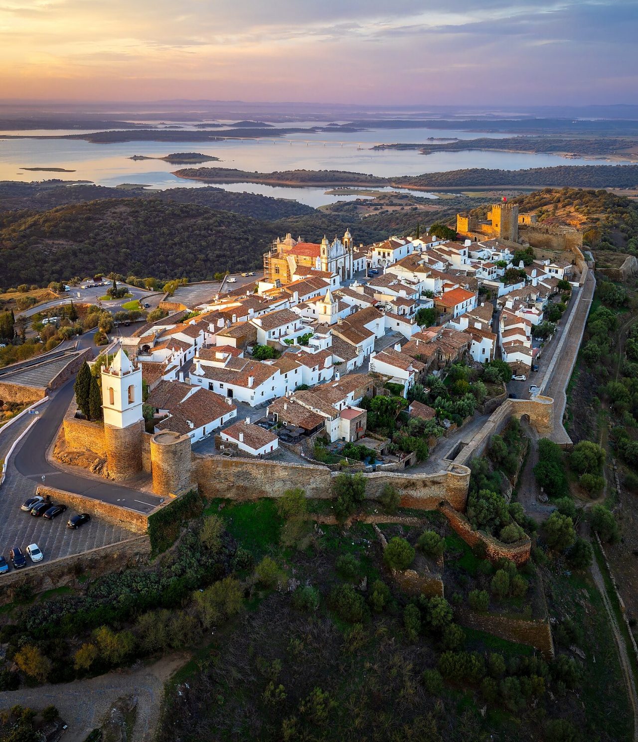 Luchtfoto van de heuvel Monsaraz in Alentejo bij zonsondergang, met een kasteel, een kathedraal en het dorp