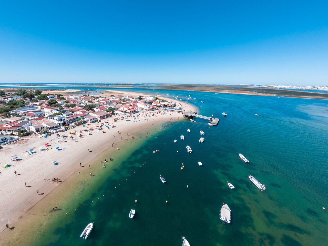 Paradijselijk luchtzicht op het eiland Armona, Algarve, met kristalhelder water en boten in Ria Formosa