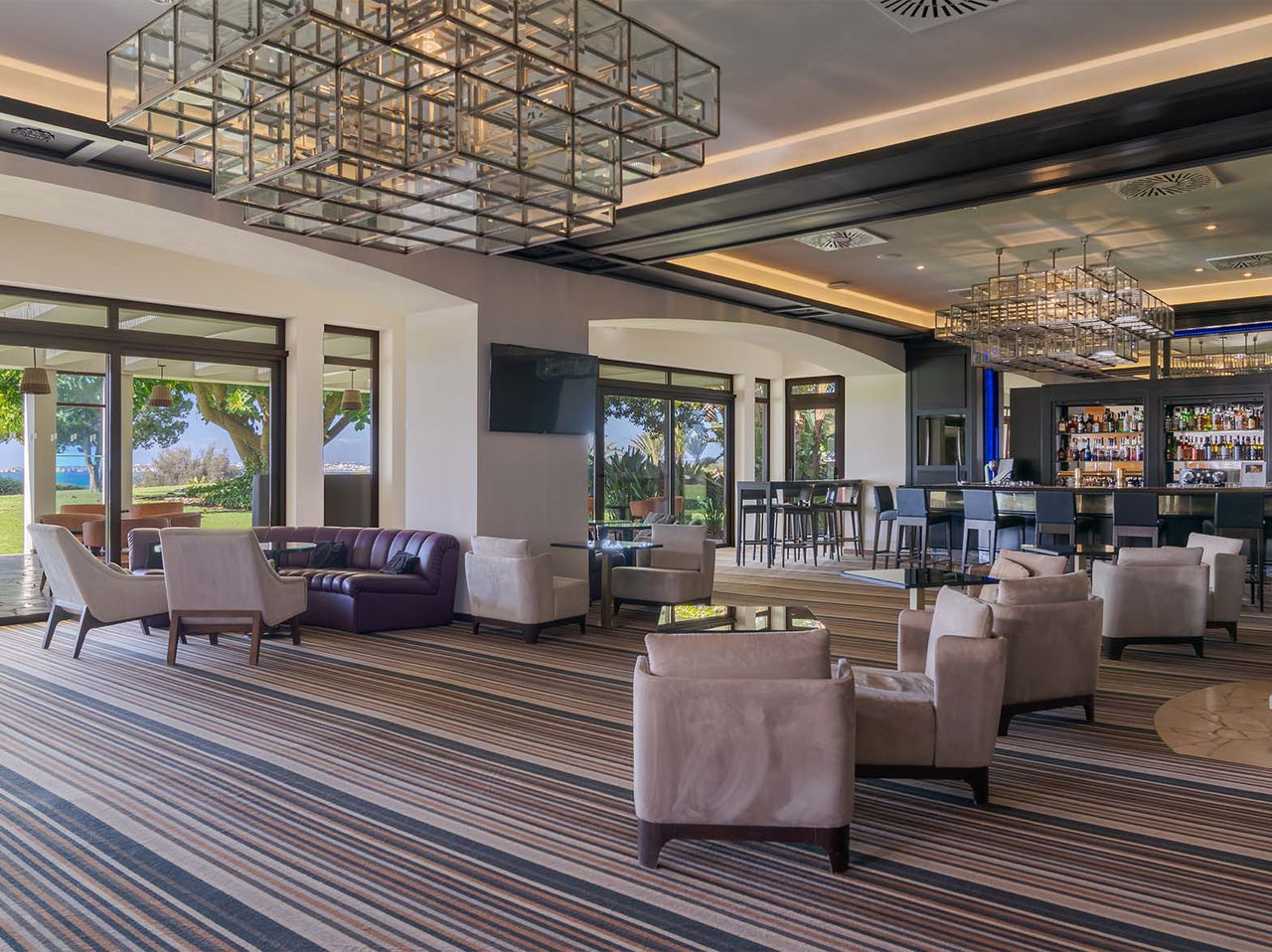 De bar D Henrique, van het 5-sterrenhotel in de Algarve, heeft banken voor drankjes en uitzicht op zee en tuin