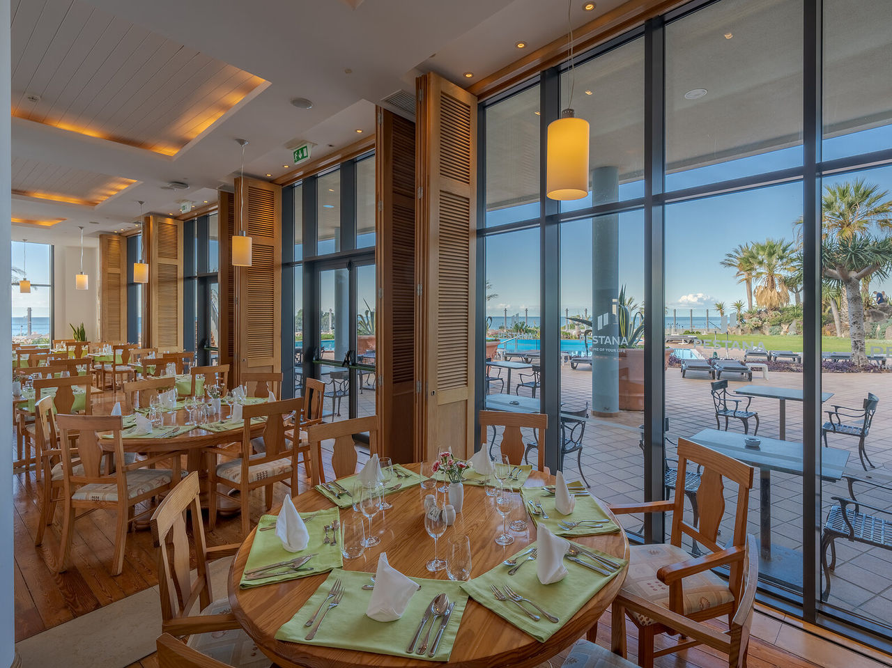 Het restaurant Cabo Girão, van het 5-sterrenhotel in Funchal, op Madeira, heeft een zaal met tafels en uitzicht op de zee