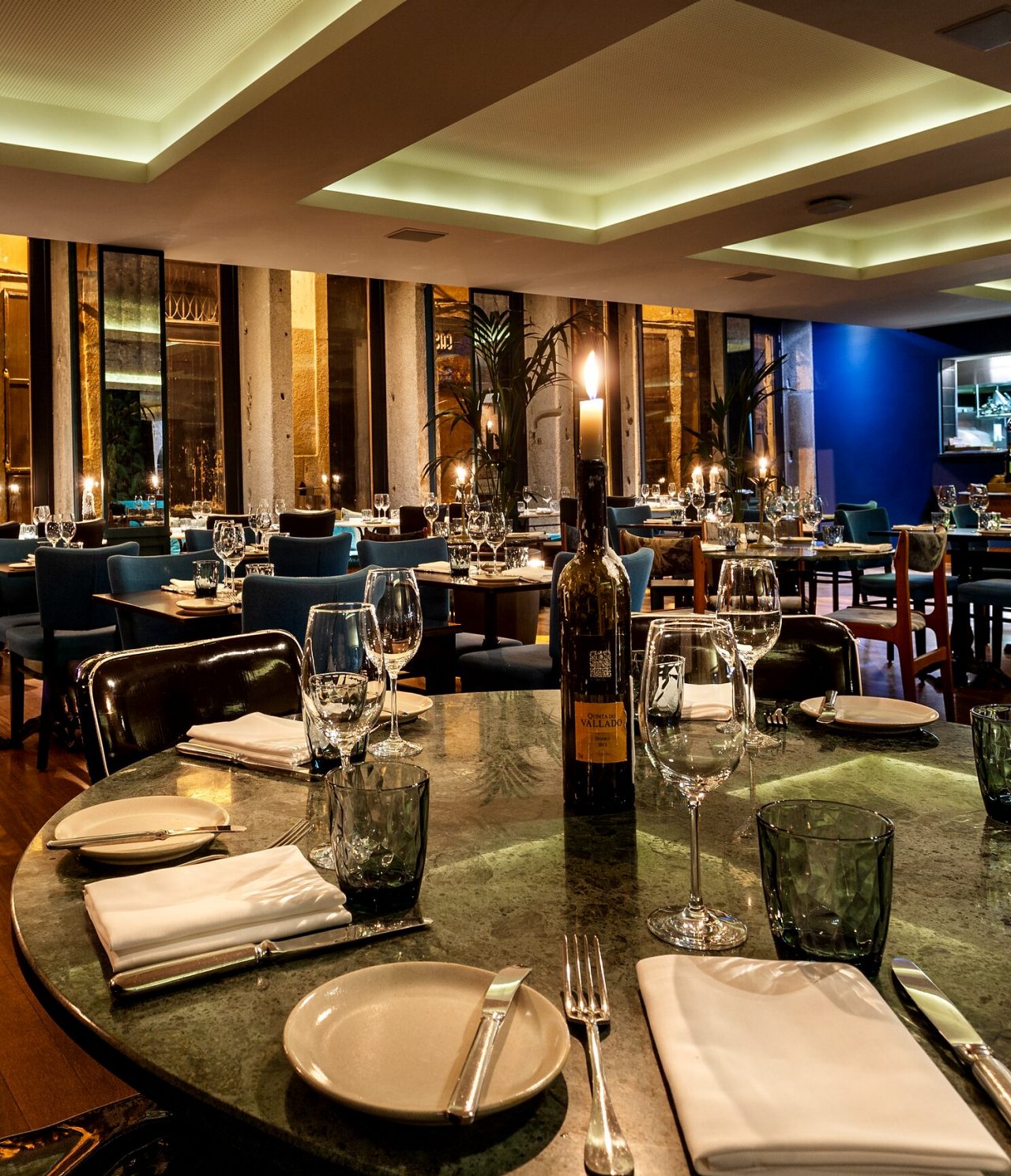 Het restaurant Rib Beef & Wine, van het 5-sterrenhotel in het centrum van Porto, heeft ronde tafels met servies en wijn