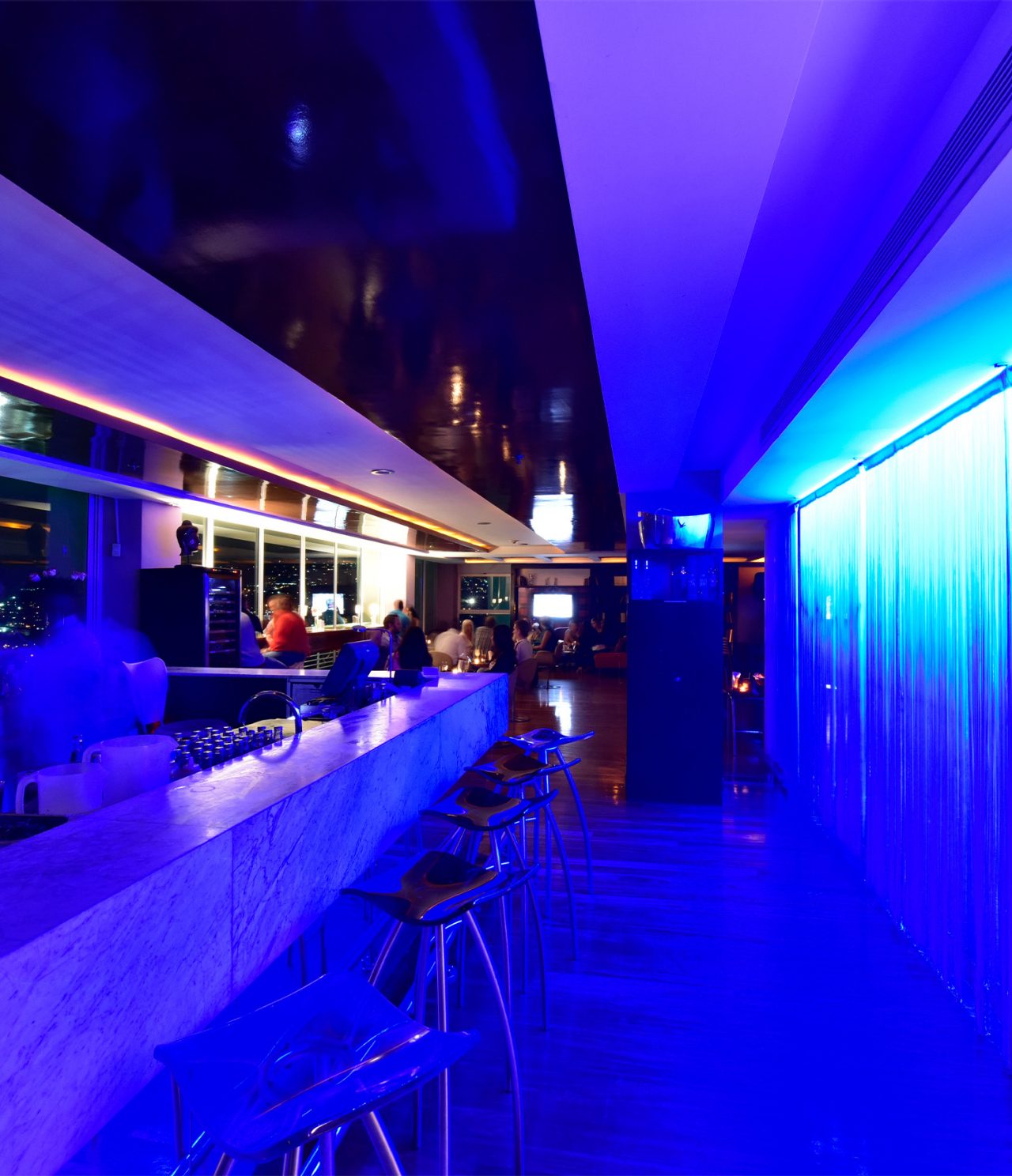 De bar Lounge Ávila, van het Hotel in Caracas, heeft hoge banken, blauwe neonlichten en serveert alcoholische dranken