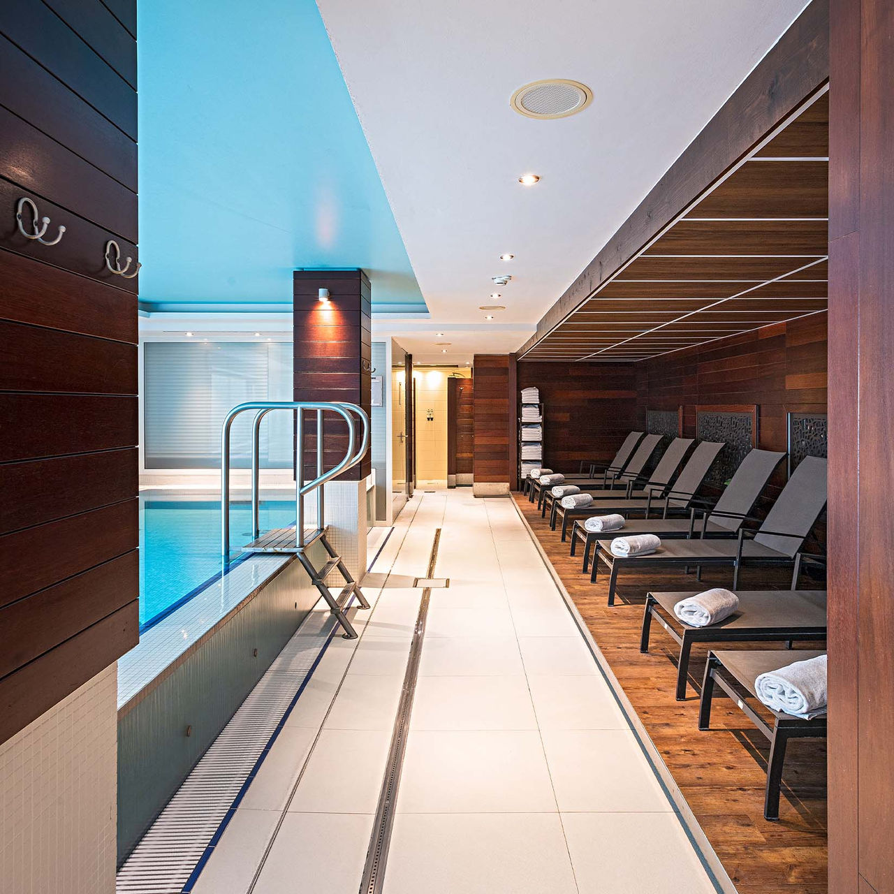 Indoor pool at Pestana Berlin, with heated light blue water and loungers around the pool
