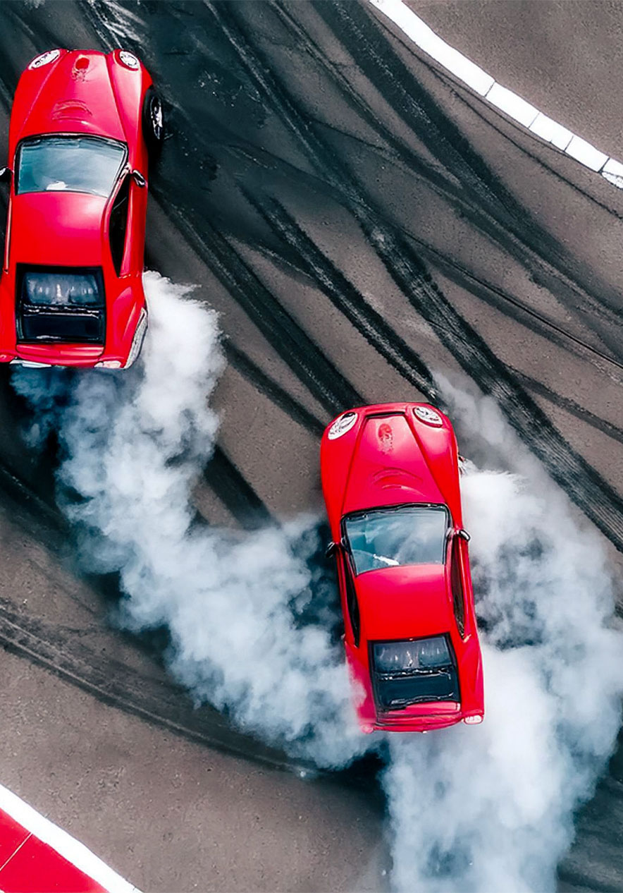 Race track with red cars braking and leaving smoke