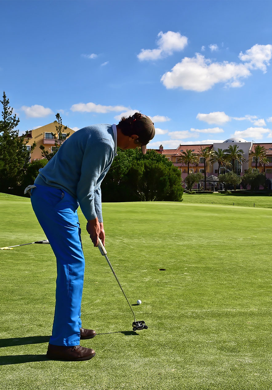 On a green golf course a man about to take a shot focused with perfect posture