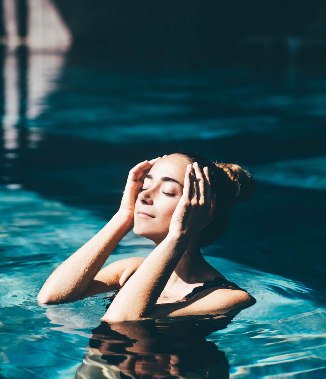A client relaxing in the Pestana Magic Spa pool under the sun, enjoying a moment of relaxation